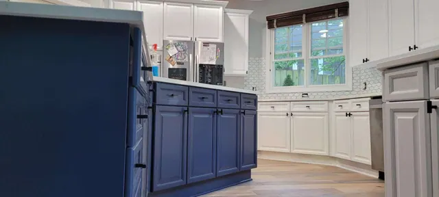 A close-up of navy blue island cabinetry against white perimeter cabinets in a remodeled kitchen.